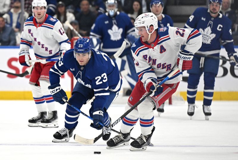 Oct 16, 2025; Toronto, Ontario, CAN; New York Rangers defenseman Adam Fox (23) moves the puck away from Toronto Maple Leafs forward Matthews Knies (23) in the first period at Scotiabank Arena. Mandatory Credit: Dan Hamilton-Imagn Images