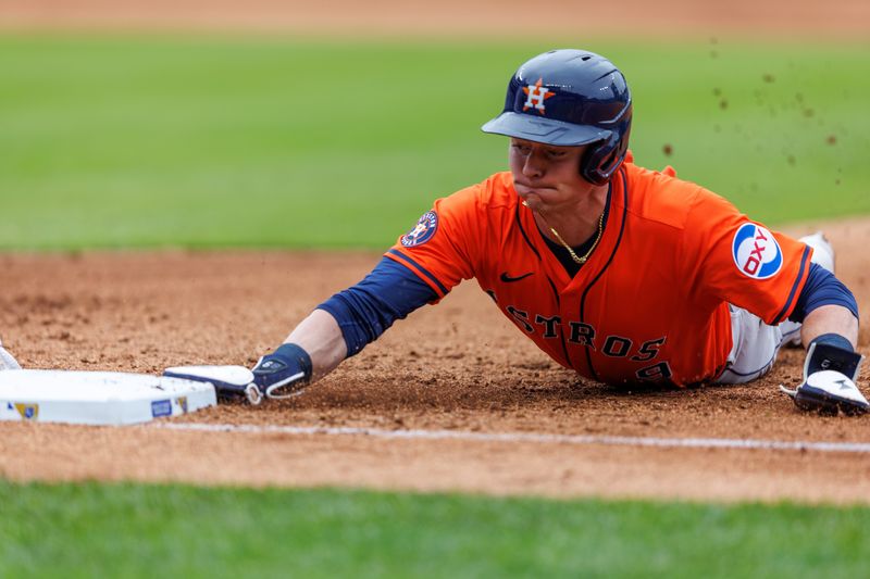 Apr 27, 2025; Kansas City, Missouri, USA; Houston Astros outfielder Zach Dezenzo (9) dives back to first base during the sixth inning against the Kansas City Royals at Kauffman Stadium. Mandatory Credit: William Purnell-Imagn Images