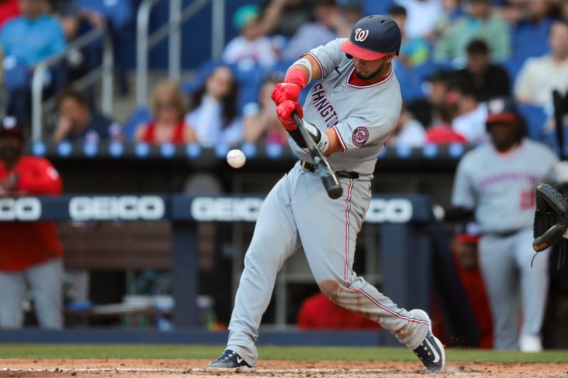 Apr 13, 2025; Miami, Florida, USA; Washington Nationals catcher Keibert Ruiz (20) hits a single against the Miami Marlins during the fifth inning at loanDepot Park. Mandatory Credit: Sam Navarro-Imagn Images