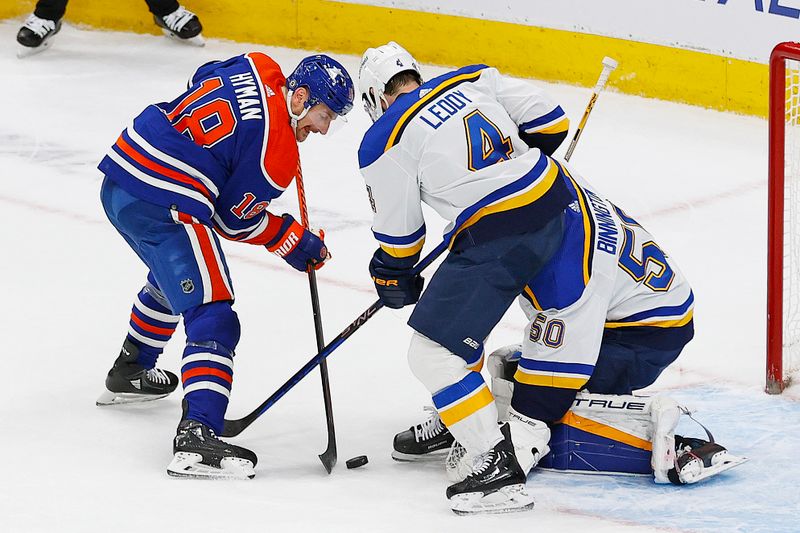 Feb 28, 2024; Edmonton, Alberta, CAN; Edmonton Oilers forward Zach Hyman (18) tries to get to a loose puck in front of St. Louis Blues goaltender Jordan Binnington (50) during the third period at Rogers Place. Mandatory Credit: Perry Nelson-USA TODAY Sports