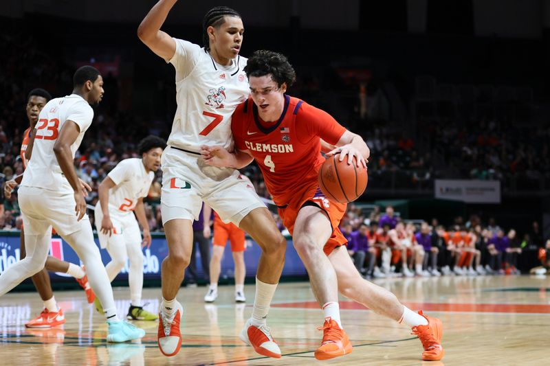 Jan 3, 2024; Coral Gables, Florida, USA; Clemson Tigers forward Ian Schieffelin (4) drives to the basket against Miami Hurricanes guard Kyshawn George (7) during the first half at Watsco Center. Mandatory Credit: Sam Navarro-USA TODAY Sports