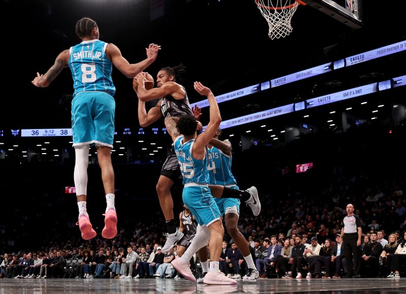 NEW YORK, NEW YORK - FEBRUARY 10: Tosan Evbuomwan #12 of the Brooklyn Nets looks to pass as Nick Smith Jr. #8 and KJ Simpson #25 of the Charlotte Hornets defend in the first half at Barclays Center on February 10, 2025 in the Brooklyn borough of New York City. NOTE TO USER: User expressly acknowledges and agrees that, by downloading and or using this photograph, User is consenting to the terms and conditions of the Getty Images License Agreement. (Photo by Elsa/Getty Images)