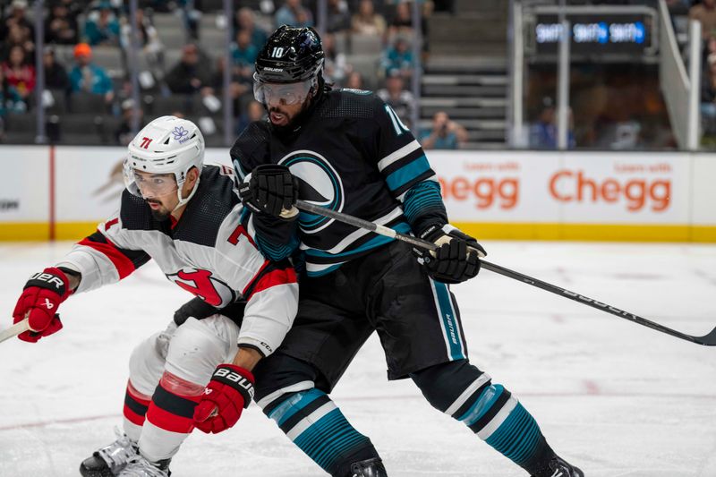 Feb 27, 2024; San Jose, California, USA;  San Jose Sharks left wing Anthony Duclair (10) checks New Jersey Devils defenseman Jonas Siegenthaler (71) into the boards during the second period at SAP Center at San Jose. Mandatory Credit: Neville E. Guard-USA TODAY Sports