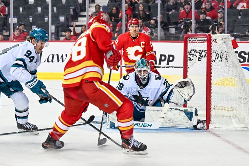 Feb 15, 2024; Calgary, Alberta, CAN; San Jose Sharks goaltender Mackenzie Blackwood (29) keeps his eye on the puck as Calgary Flames left wing Andrew Mangiapane (88) tries to score during the third period at Scotiabank Saddledome. Mandatory Credit: Brett Holmes-USA TODAY Sports