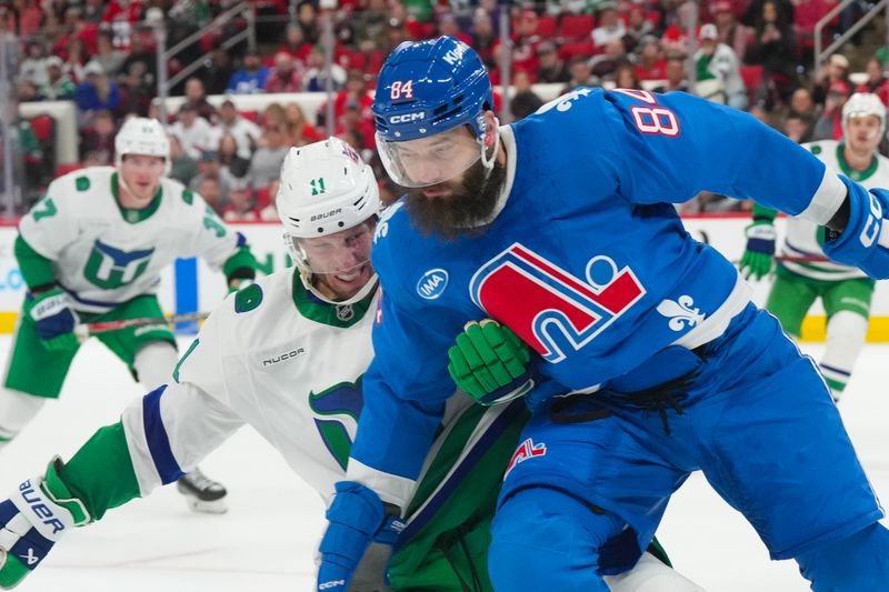 Jan 3, 2026; Raleigh, North Carolina, USA; Colorado Avalanche defenseman Brent Burns (84) and Carolina Hurricanes center Jordan Staal (11) battle during the third period at Lenovo Center. Mandatory Credit: James Guillory-Imagn Images