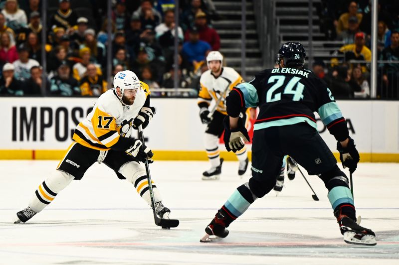 Oct 29, 2022; Seattle, Washington, USA; Pittsburgh Penguins right wing Bryan Rust (17) advances the puck against Seattle Kraken defenseman Jamie Oleksiak (24) during the third period at Climate Pledge Arena. Seattle won 3-1. Mandatory Credit: Steven Bisig-USA TODAY Sports