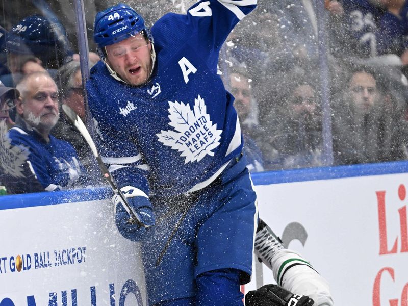 Feb 7, 2024; Toronto, Ontario, CAN; Toronto Maple Leafs defenseman Morgan Rielly (44) and Dallas Stars forward Radek Faksa (12) battles for the puck in the second period at Scotiabank Arena. Mandatory Credit: Dan Hamilton-USA TODAY Sports