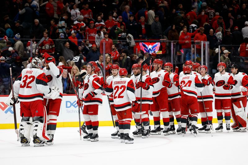 Dec 11, 2025; Washington, District of Columbia, USA; Carolina Hurricanes goaltender Brandon Bussi (32) celebrates with teammates after their game against the Washington Capitals at Capital One Arena. Mandatory Credit: Geoff Burke-Imagn Images