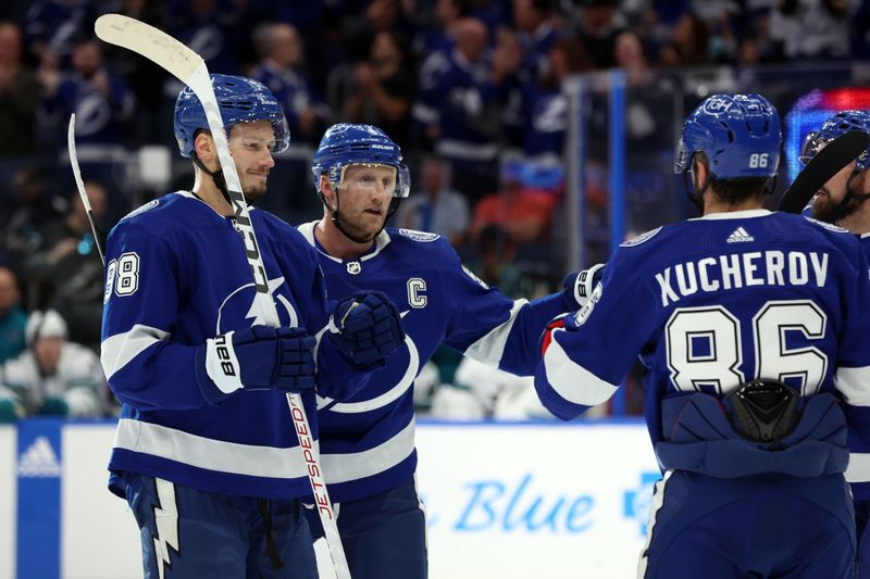 Oct 26, 2023; Tampa, Florida, USA; Tampa Bay Lightning center Steven Stamkos (91) is congratulated by  defenseman Mikhail Sergachev (98) and right wing Nikita Kucherov (86) after he scored against the San Jose Sharks during the first period at Amalie Arena. Mandatory Credit: Kim Klement Neitzel-USA TODAY Sports