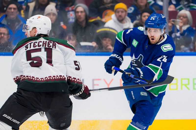 Jan 18, 2024; Vancouver, British Columbia, CAN; Vancouver Canucks forward Pius Suter (24) shoots around Arizona Coyotes defenseman Troy Stecher (51) in the third period at Rogers Arena. Vancouver won 2-1. Mandatory Credit: Bob Frid-USA TODAY Sports