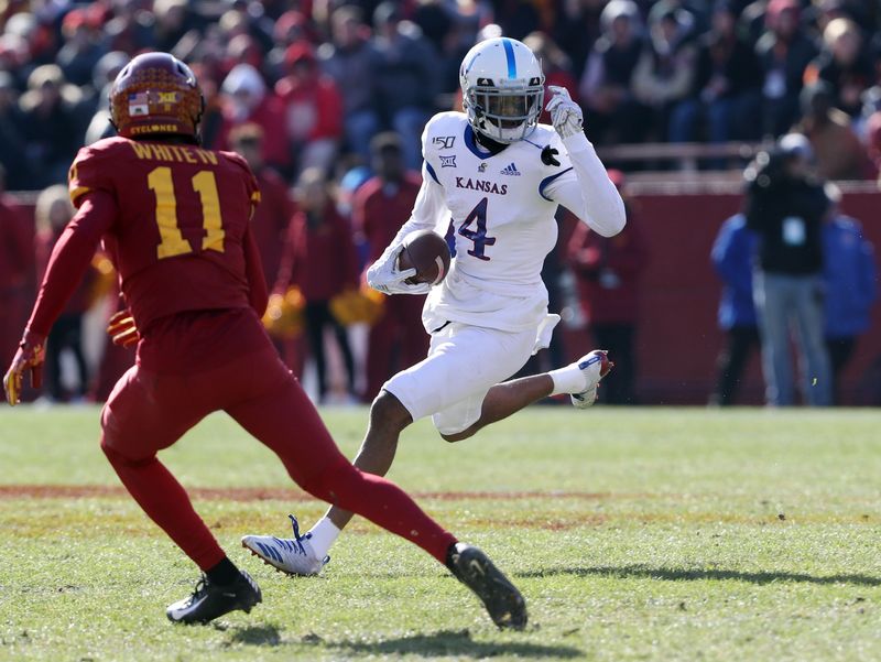 Nov 23, 2019; Ames, IA, USA; Kansas Jayhawks wide receiver Andrew Parchment (4) runs away from Iowa State Cyclones defensive back Lawrence White (11) at Jack Trice Stadium. Mandatory Credit: Reese Strickland-USA TODAY Sports