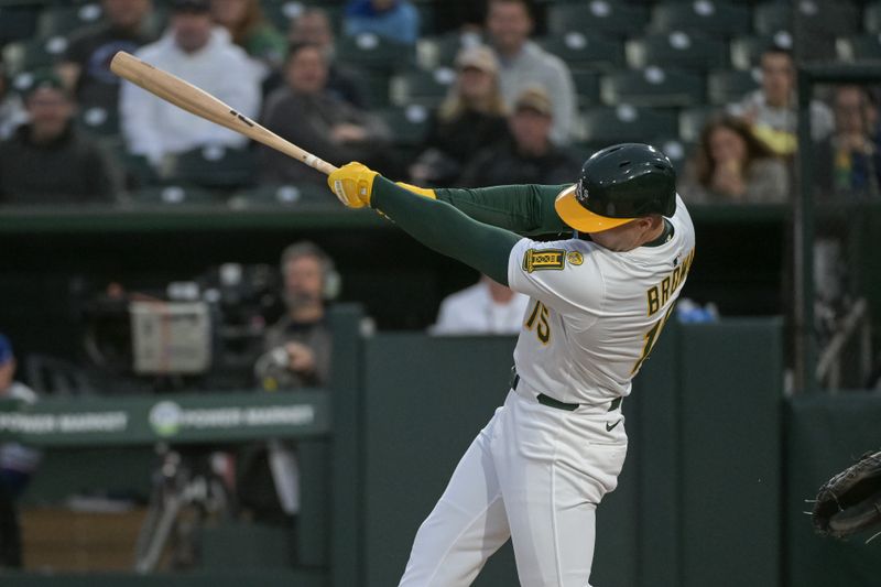 Apr 24, 2025; West Sacramento, California, USA; Athletics outfielder Seth Brown (15) hits a double against the Texas Rangers during the second inning at Sutter Health Park. Mandatory Credit: Ed Szczepanski-Imagn Images