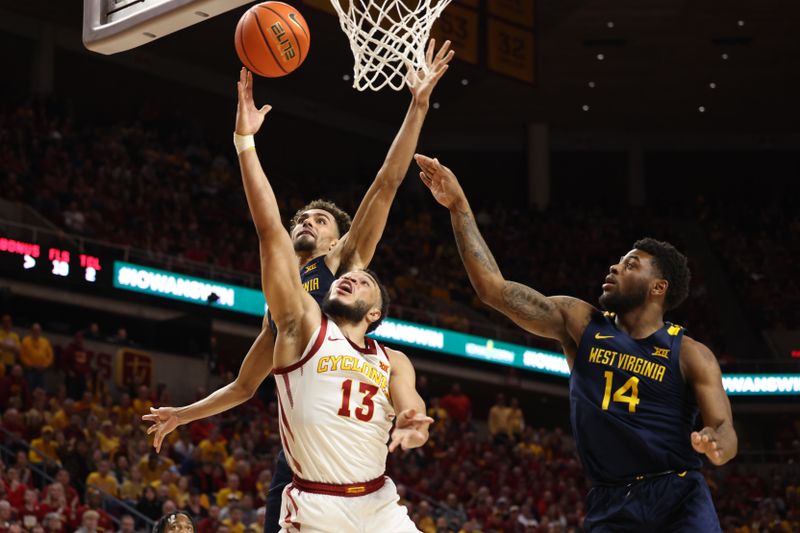 Feb 27, 2023; Ames, Iowa, USA; Iowa State Cyclones guard Jaren Holmes (13) splits the defense from West Virginia Mountaineers forward Emmitt Matthews Jr. (1) and West Virginia Mountaineers guard Seth Wilson (14) during the second half at James H. Hilton Coliseum. Mandatory Credit: Reese Strickland-USA TODAY Sports