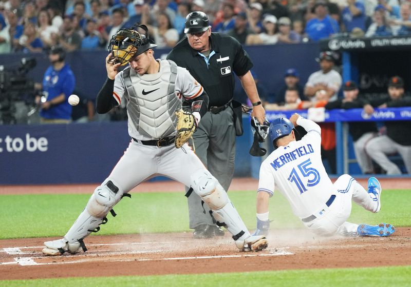 Jun 28, 2023; Toronto, Ontario, CAN; Toronto Blue Jays left fielder Whit Merrifield (15) slides into home plate ahead of the tag from San Francisco Giants catcher Patrick Bailey (14) during the first inning at Rogers Centre. Mandatory Credit: Nick Turchiaro-USA TODAY Sports