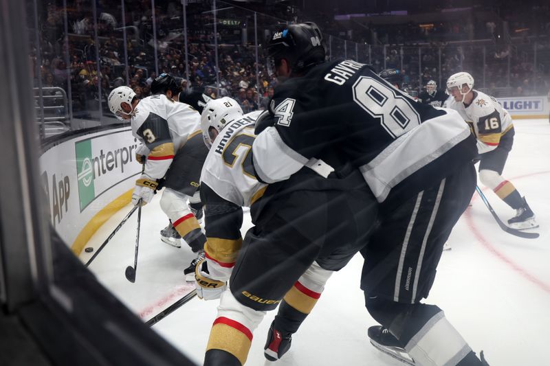 Oct 30, 2024; Los Angeles, California, USA;  Vegas Golden Knights defenseman Brayden McNabb (3) and Los Angeles Kings right wing Alex Laferriere (14) fight for the puck during the first period at Crypto.com Arena. Mandatory Credit: Kiyoshi Mio-Imagn Images