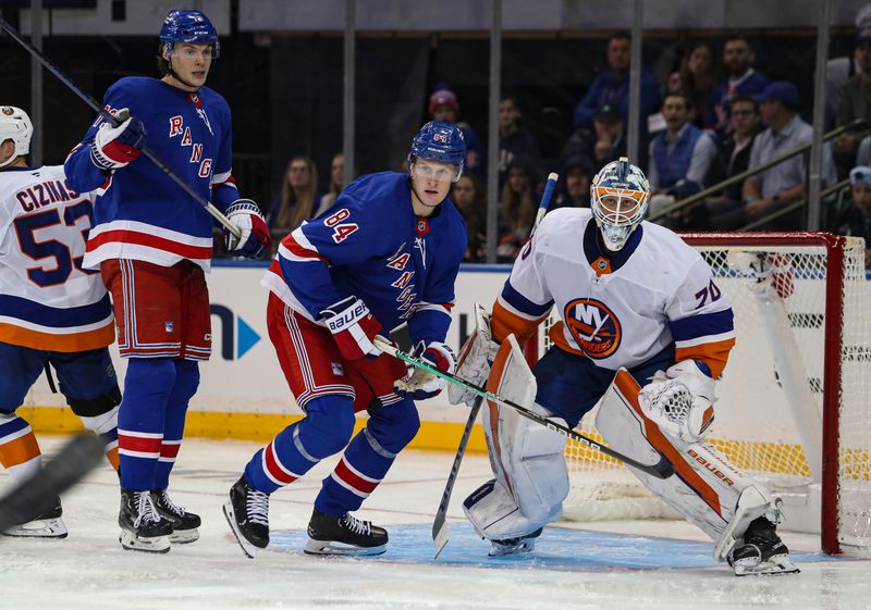 Sep 24, 2024; New York, New York, USA; New York Rangers center Matt Rempe (73) and center Adam Edstrom (84) battle for position in front of New York Islanders goalie Henrik Tikkanen (70) during the third period at Madison Square Garden. Mandatory Credit: Danny Wild-Imagn Images