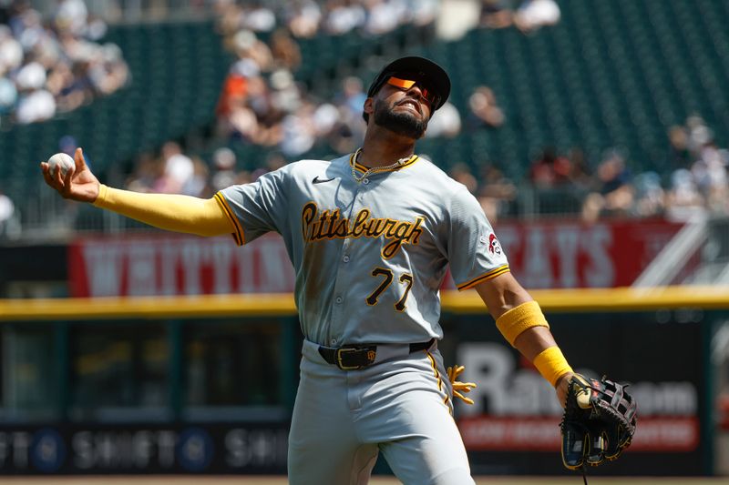 Jul 14, 2024; Chicago, Illinois, USA; Pittsburgh Pirates outfielder Joshua Palacios (77) throws a baseball to a fan during a baseball game against the Chicago White Sox at Guaranteed Rate Field. Mandatory Credit: Kamil Krzaczynski-USA TODAY Sports