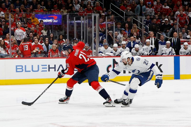 Mar 1, 2025; Washington, District of Columbia, USA; Washington Capitals center Aliaksei Protas (21) skates with the puck as Tampa Bay Lightning left wing Nick Paul (20) chases in the third period at Capital One Arena. Mandatory Credit: Geoff Burke-Imagn Images