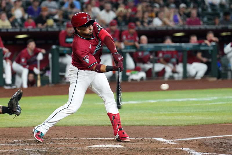 Jul 28, 2024; Phoenix, Arizona, USA; Arizona Diamondbacks third base Eugenio Suárez (28) hits a sacrifice fly RBI against the Pittsburgh Pirates during the fourth inning at Chase Field. Mandatory Credit: Joe Camporeale-USA TODAY Sports