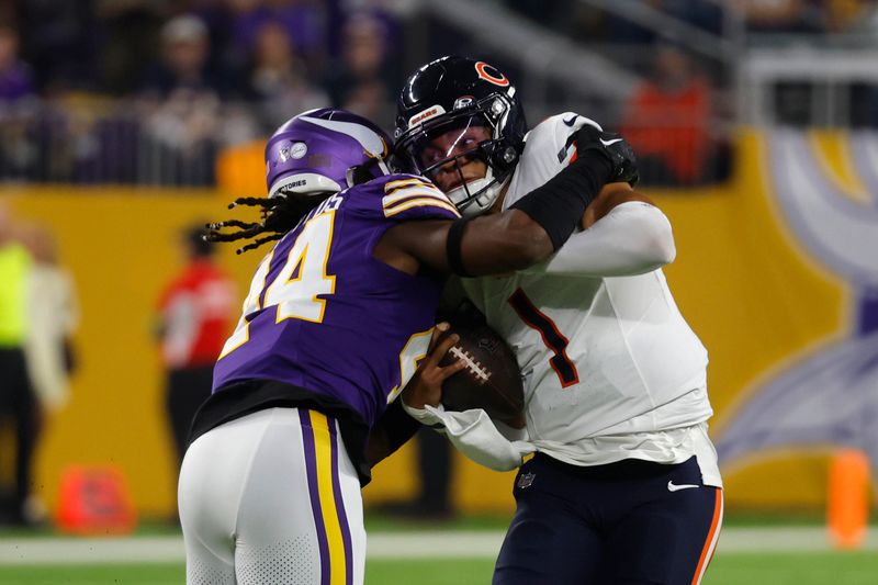 Chicago Bears quarterback Justin Fields (1) is tackled by Minnesota Vikings safety Josh Metellus (44) during the first half of an NFL football game, Monday, Nov. 27, 2023, in Minneapolis. (AP Photo/Bruce Kluckhohn)