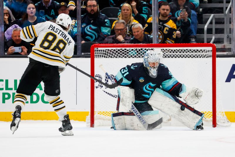 Feb 26, 2024; Seattle, Washington, USA; Seattle Kraken goaltender Philipp Grubauer (31) makes a save against Boston Bruins right wing David Pastrnak (88) during an overtime shootout at Climate Pledge Arena. Mandatory Credit: Joe Nicholson-USA TODAY Sports