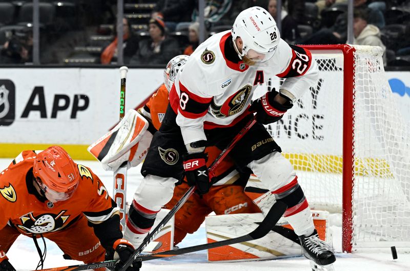 Dec 1, 2024; Anaheim, California, USA;  Anaheim Ducks defenseman Olen Zellweger (51) redirects the puck away from Ottawa Senators right wing Claude Giroux (28) with goaltender Lukas Dostal (1) defending during the third period at Honda Center. Mandatory Credit: Alex Gallardo-Imagn Images