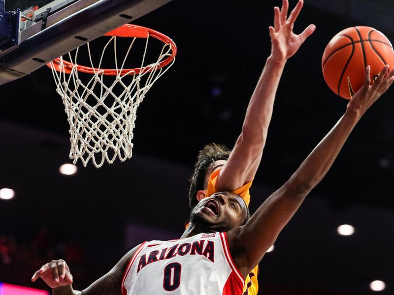 Jan 14, 2026; Tucson, Arizona, USA; Arizona Wildcats guard Jaden Bradley (0) makes a lay up while Arizona State Sun Devils forward Santiago Trouet (1) fails to block him during the second half of the game at McKale Memorial Center. Mandatory Credit: Aryanna Frank-Imagn Images