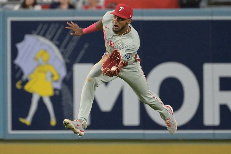 Aug 7, 2024; Los Angeles, California, USA;  Philadelphia Phillies center fielder Johan Rojas (18) makes a running catch off a ball hit by Los Angeles Dodgers first baseman Freddie Freeman (5) in the eighth inning at Dodger Stadium. Mandatory Credit: Jayne Kamin-Oncea-USA TODAY Sports