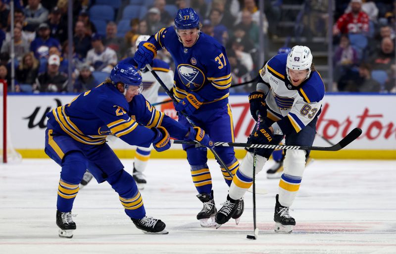 Feb 10, 2024; Buffalo, New York, USA;  St. Louis Blues left wing Jake Neighbours (63) carries the puck up ice as Buffalo Sabres defenseman Rasmus Dahlin (26) defends during the first period at KeyBank Center. Mandatory Credit: Timothy T. Ludwig-USA TODAY Sports