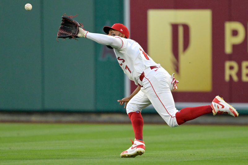 Jun 4, 2024; Anaheim, California, USA;  Los Angeles Angels right fielder Jo Adell (7) makes a running catch off a ball hit by San Diego Padres center fielder Jackson Merrill (3) in the sixth inning at Angel Stadium. Mandatory Credit: Jayne Kamin-Oncea-USA TODAY Sports