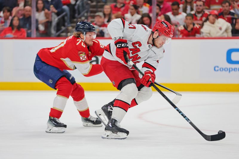 May 26, 2025; Sunrise, Florida, USA; Carolina Hurricanes defenseman Alexander Nikishin (21) moves the puck past Florida Panthers center Evan Rodrigues (17) during the third period in game four of the Eastern Conference Final of the 2025 Stanley Cup Playoffs at Amerant Bank Arena. Mandatory Credit: Sam Navarro-Imagn Images