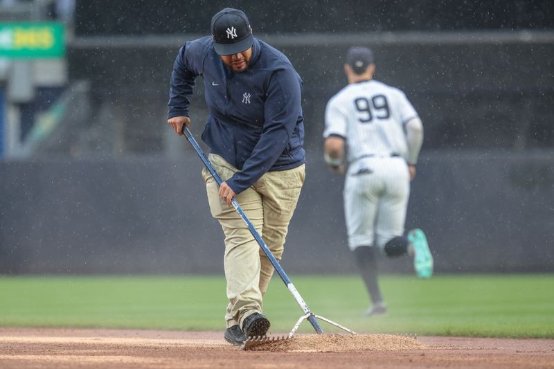 May 5, 2024; Bronx, New York, USA; A member of the Yankees grounds crew works on the field during the sixth inning of the game as New York Yankees center fielder Aaron Judge (99) runs out against the Detroit Tigers at Yankee Stadium. Mandatory Credit: Vincent Carchietta-USA TODAY Sports