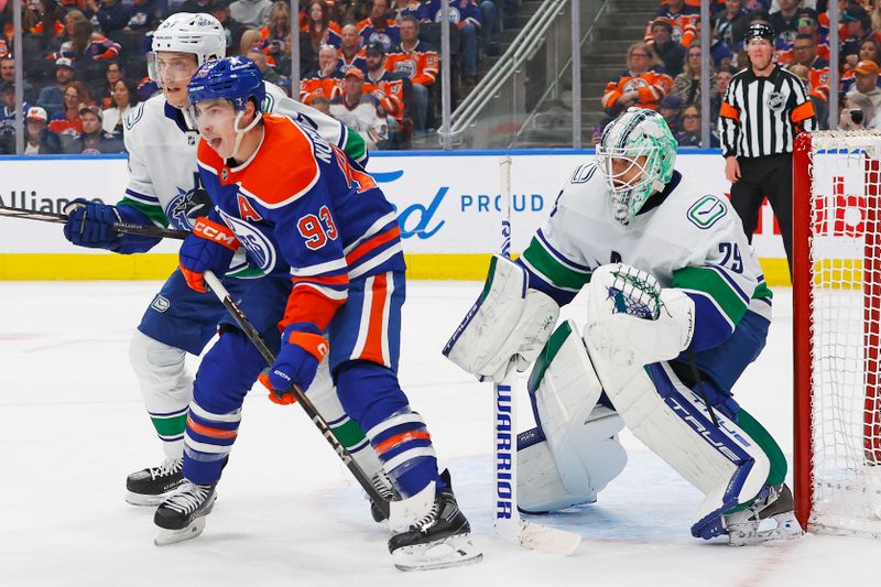 Apr 13, 2024; Edmonton, Alberta, CAN; Edmonton Oilers forward Ryan Nugent-Hopkins (93) battles with Vancouver Canucks defensemen Tyler Myers (57) in front of goaltender Casey DeSmith (29) during the third period at Rogers Place. Mandatory Credit: Perry Nelson-USA TODAY Sports
