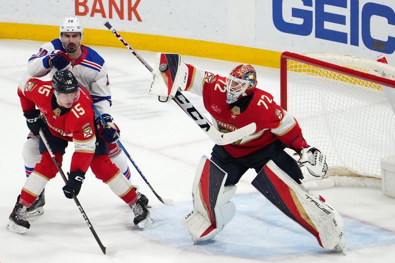 Dec 29, 2023; Sunrise, Florida, USA; Florida Panthers goaltender Sergei Bobrovsky (72) blocks the puck behind center Anton Lundell (15) and New York Rangers left wing Chris Kreider (20) during the third period at Amerant Bank Arena. Mandatory Credit: Jasen Vinlove-USA TODAY Sports