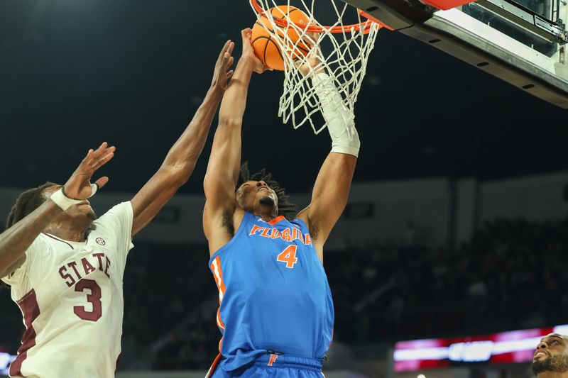 Feb 11, 2025; Starkville, Mississippi, USA; Florida Gators forward Sam Alexis (4) dunks the ball against Mississippi State Bulldogs forward KeShawn Murphy (3) during the first half at Humphrey Coliseum. Mandatory Credit: Wesley Hale-Imagn Images