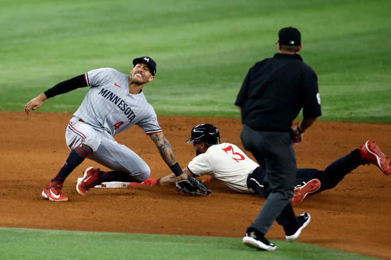 Sep 2, 2023; Arlington, Texas, USA; Texas Rangers center fielder Leody Taveras (3) steals second base as Minnesota Twins shortstop Carlos Correa (4) attempts to make the tag in the seventh inning at Globe Life Field. Mandatory Credit: Tim Heitman-USA TODAY Sports