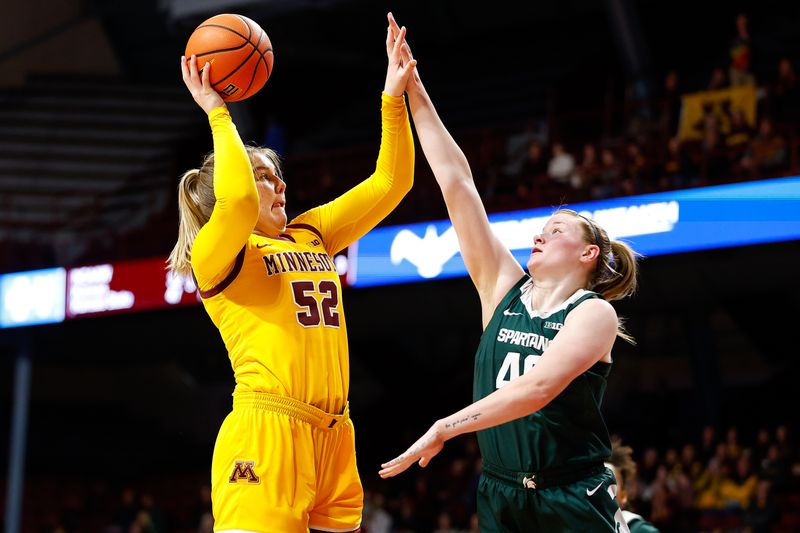 Jan 20, 2024; Minneapolis, Minnesota, USA; Minnesota Golden Gophers center Sophie Hart (52) shoots as Michigan State Spartans guard Julia Ayrault (40) defends during the first half at Williams Arena. Mandatory Credit: Matt Krohn-USA TODAY Sports