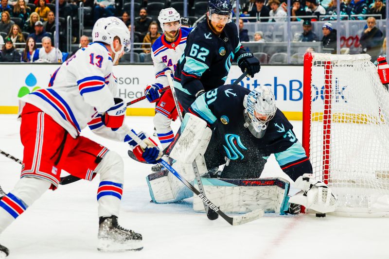 Nov 17, 2024; Seattle, Washington, USA; Seattle Kraken goaltender Philipp Grubauer (31) makes a save against New York Rangers left wing Alexis Lafrenière (13) during the second period at Climate Pledge Arena. Seattle Kraken defenseman Brandon Montour (62) follows the play behind Grubauer. Mandatory Credit: Joe Nicholson-Imagn Images