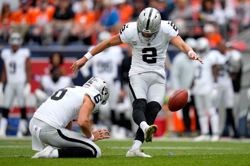 Las Vegas Raiders kicker Daniel Carlson (2) kicks a field goal as punter AJ Cole (6) holds during the first half of an NFL football game against the Denver Broncos, Sunday, Sept. 10, 2023, in Denver. (AP Photo/Jack Dempsey)