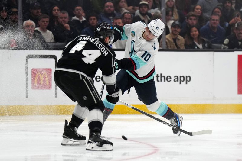 Dec 20, 2023; Los Angeles, California, USA; Seattle Kraken center Matty Beniers (10) shoots the puck against LA Kings defenseman Mikey Anderson (44) in the third period at Crypto.com Arena. Mandatory Credit: Kirby Lee-USA TODAY Sports