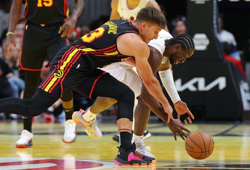 ATLANTA, GEORGIA - NOVEMBER 29:  Caris LeVert #3 of the Cleveland Cavaliers strips the ball away from Bogdan Bogdanovic #13 of the Atlanta Hawks during the fourth quarter of the Emirates NBA Cup game at State Farm Arena on November 29, 2024 in Atlanta, Georgia.  NOTE TO USER: User expressly acknowledges and agrees that, by downloading and/or using this photograph, user is consenting to the terms and conditions of the Getty Images License Agreement.  (Photo by Kevin C. Cox/Getty Images)