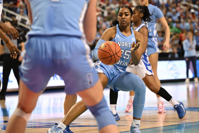 Mar 3, 2023; Greensboro, NC, USA; North Carolina Tar Heels guard Deja Kelly (25) passes to North Carolina Tar Heels guard Alyssa Ustby (1) during the first half at Greensboro Coliseum. Mandatory Credit: William Howard-USA TODAY Sports