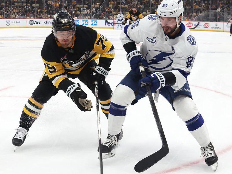 Jan 13, 2026; Pittsburgh, Pennsylvania, USA;  Pittsburgh Penguins defenseman Connor Clifton (75) and Tampa Bay Lightning right wing Nikita Kucherov (86) chase the puck during the first period at PPG Paints Arena. Mandatory Credit: Charles LeClaire-Imagn Images