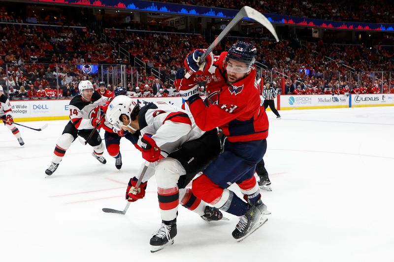 Oct 12, 2024; Washington, District of Columbia, USA; Washington Capitals right wing Tom Wilson (43) and New Jersey Devils defenseman Johnathan Kovacevic (8) battle for the puck in the third period at Capital One Arena. Mandatory Credit: Geoff Burke-Imagn Images