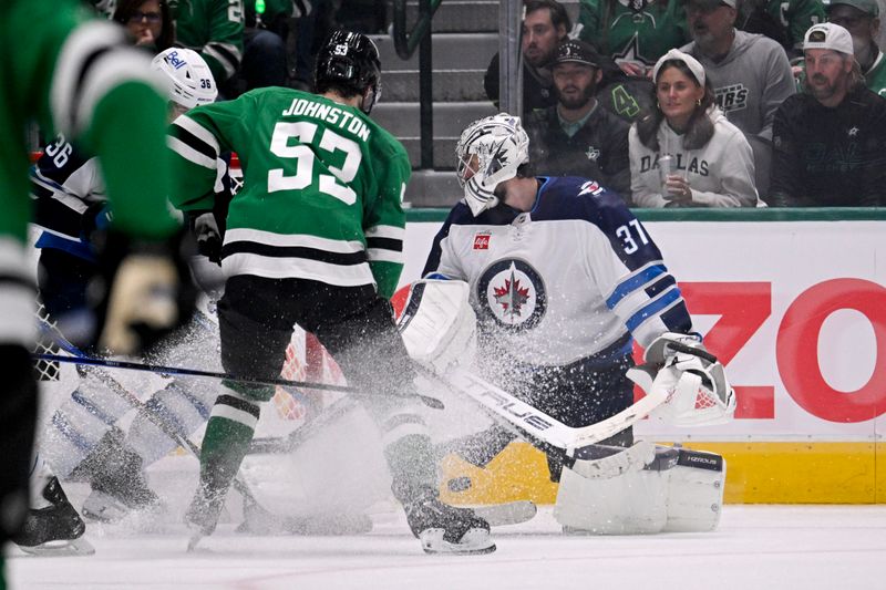 May 11, 2025; Dallas, Texas, USA; Dallas Stars center Wyatt Johnston (53) scores a goal against Winnipeg Jets goaltender Connor Hellebuyck (37) during the third period in game three of the second round of the 2025 Stanley Cup Playoffs at American Airlines Center. Mandatory Credit: Jerome Miron-Imagn Images