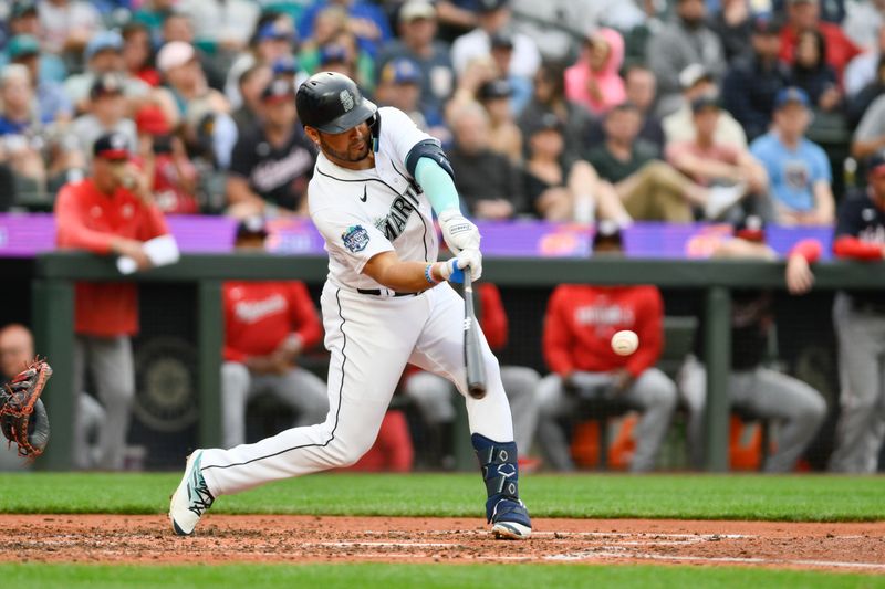 Jun 27, 2023; Seattle, Washington, USA; Seattle Mariners third baseman Eugenio Suarez (28) hits a sacrifice fly ball against the Washington Nationals during the fourth inning at T-Mobile Park. Mandatory Credit: Steven Bisig-USA TODAY Sports