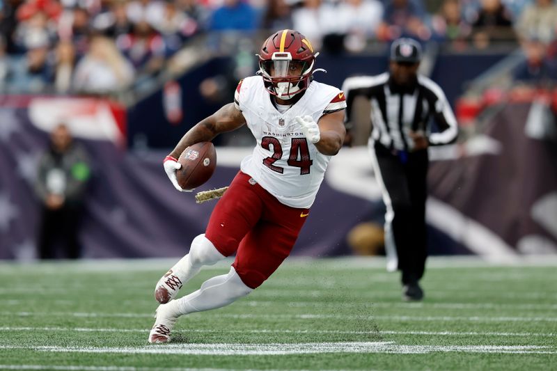 Washington Commanders running back Antonio Gibson (24) carries the ball in the first half of an NFL football game against the New England Patriots, Sunday, Nov. 5, 2023, in Foxborough, Mass. (AP Photo/Michael Dwyer)