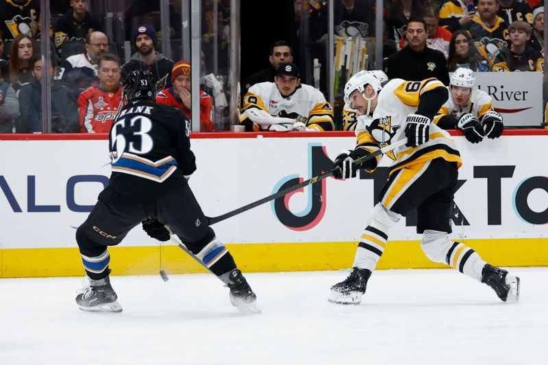 Jan 18, 2025; Washington, District of Columbia, USA; Pittsburgh Penguins defenseman Erik Karlsson (65) shoots the puck as Washington Capitals center Ethen Frank (53) defends in the second period at Capital One Arena. Mandatory Credit: Geoff Burke-Imagn Images