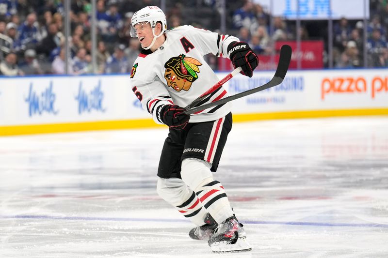 Dec 2, 2024; Toronto, Ontario, CAN; Chicago Blackhawks defenseman Connor Murphy (5) breaks his stick on a slapshot against the Toronto Maple Leafs during the second period at Scotiabank Arena. Mandatory Credit: John E. Sokolowski-Imagn Images