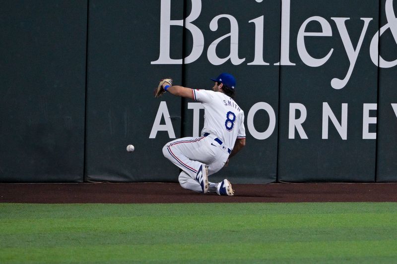 Aug 7, 2024; Arlington, Texas, USA;  Texas Rangers left fielder Josh Smith (8) slides but cannot make the catch of a ball hit by Houston Astros first baseman Zach Dezenzo (not pictured) during the second inning at Globe Life Field. Mandatory Credit: Jerome Miron-USA TODAY Sports